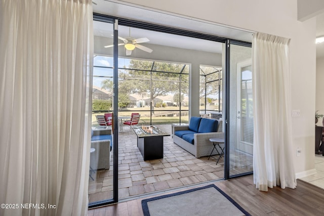 interior space featuring wood finished floors, a sunroom, and a ceiling fan