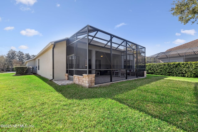 back of house featuring a lanai, a yard, a patio area, and stucco siding