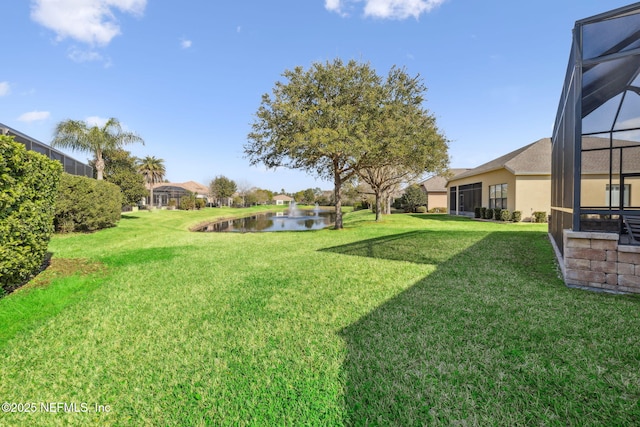 view of yard with a water view and a lanai