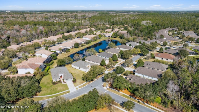 birds eye view of property featuring a water view, a residential view, and a wooded view