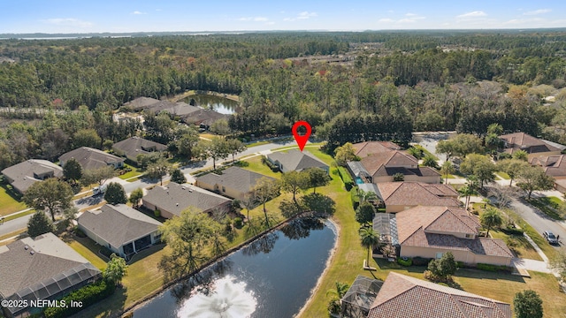 drone / aerial view with a water view, a forest view, and a residential view