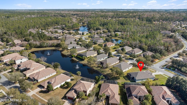 aerial view featuring a residential view, a water view, and a wooded view