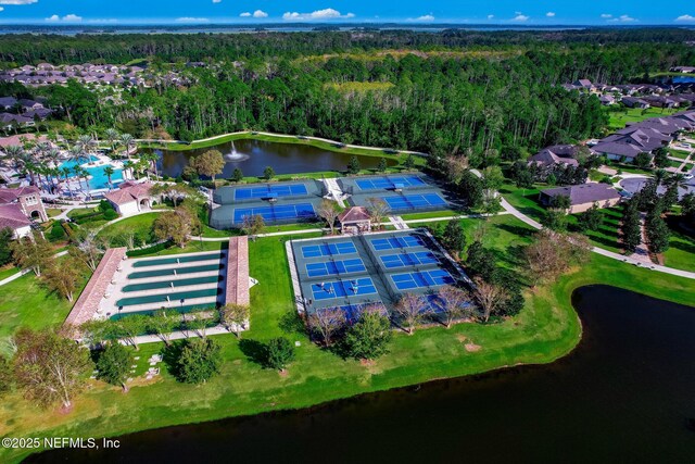 birds eye view of property featuring a water view and a wooded view