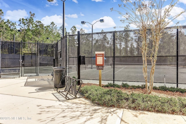 view of sport court with a gate and fence