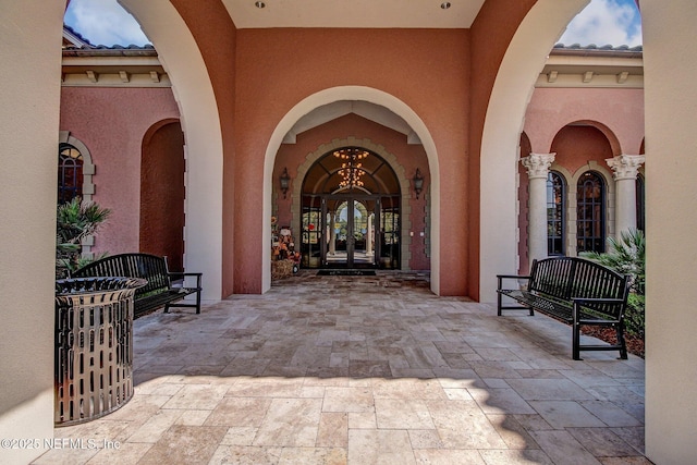 property entrance featuring french doors, a tiled roof, and stucco siding