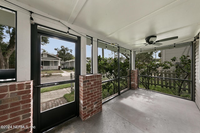 unfurnished sunroom with ceiling fan