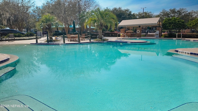 pool featuring a jacuzzi, fence, and a patio