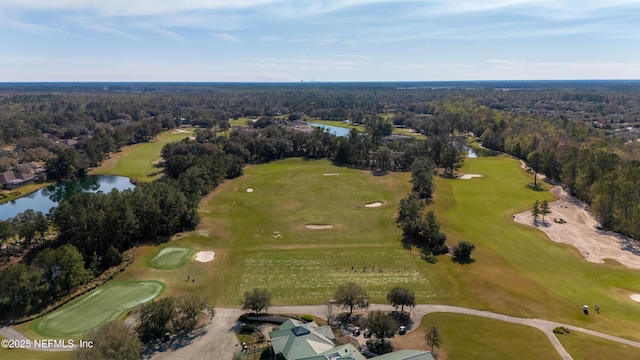 aerial view with golf course view, a water view, and a view of trees