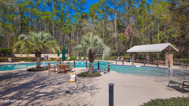 pool featuring fence and a patio