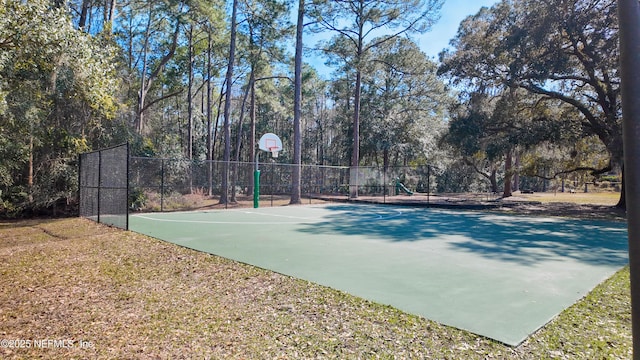 view of basketball court featuring community basketball court, fence, and playground community