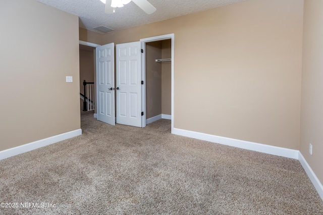 unfurnished bedroom featuring carpet floors, visible vents, a textured ceiling, and baseboards