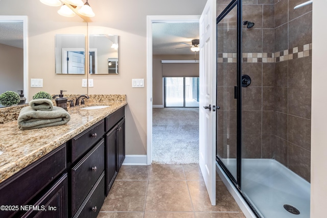 bathroom featuring a textured ceiling, a stall shower, vanity, and tile patterned floors