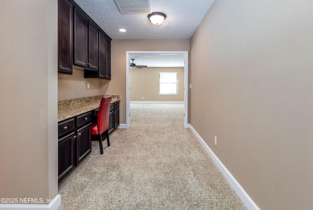 interior space with baseboards, light carpet, visible vents, and a textured ceiling