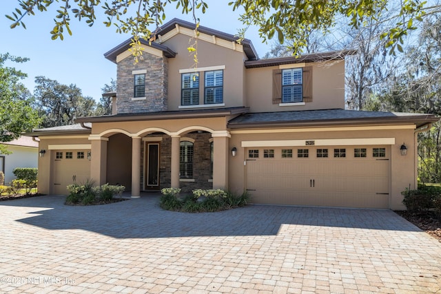 view of front facade with decorative driveway, stone siding, and stucco siding