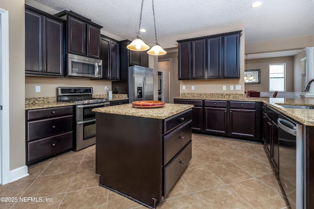 kitchen featuring a center island, light tile patterned floors, appliances with stainless steel finishes, a sink, and light stone countertops