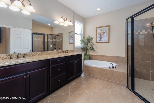 bathroom with a garden tub, double vanity, a stall shower, a sink, and tile patterned flooring