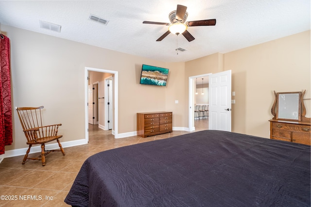 bedroom featuring tile patterned flooring, visible vents, and a textured ceiling