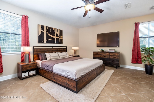 tiled bedroom featuring ceiling fan, visible vents, and baseboards