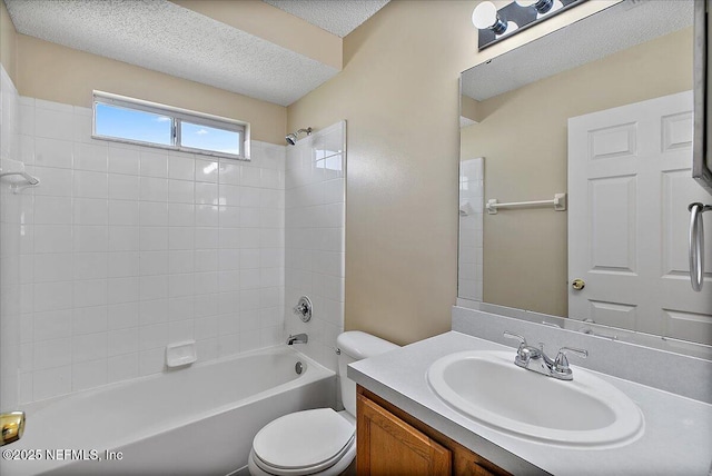 full bathroom with tub / shower combination, a textured ceiling, toilet, and vanity