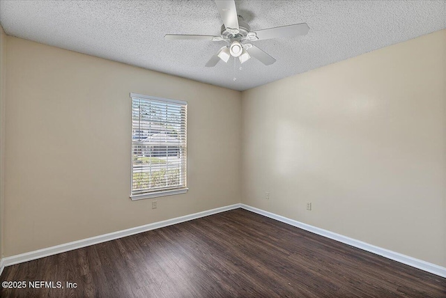 empty room featuring a ceiling fan, dark wood-style flooring, a textured ceiling, and baseboards