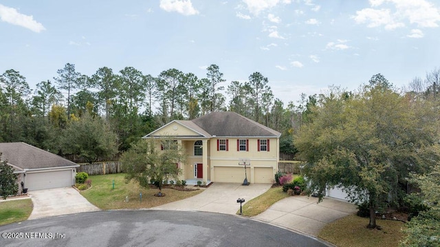 view of front facade with driveway, fence, a front lawn, and stucco siding