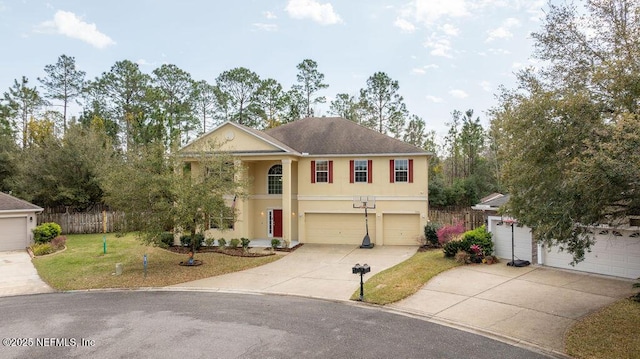 view of front facade with a garage, fence, concrete driveway, stucco siding, and a front yard