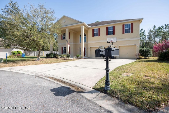 greek revival house with stucco siding, an attached garage, a front yard, fence, and driveway