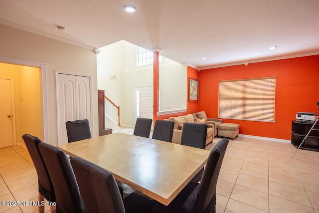 dining space with light tile patterned flooring, crown molding, and stairs