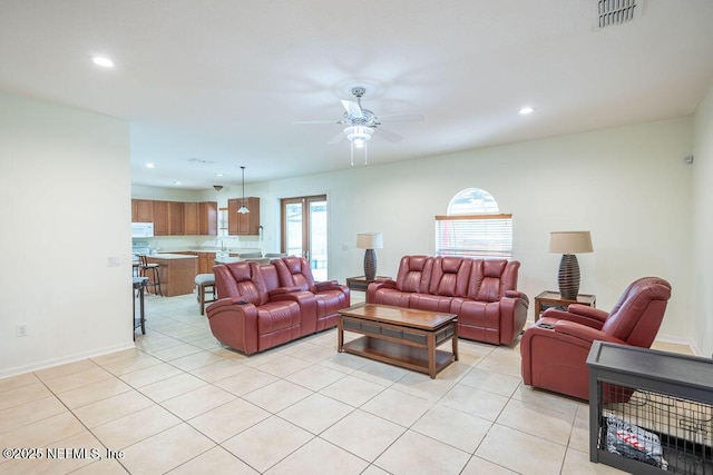 living room with light tile patterned floors, visible vents, baseboards, ceiling fan, and recessed lighting