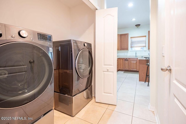 laundry area with laundry area, independent washer and dryer, and light tile patterned floors