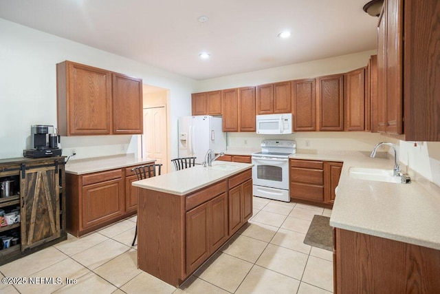 kitchen with light countertops, white appliances, and a sink