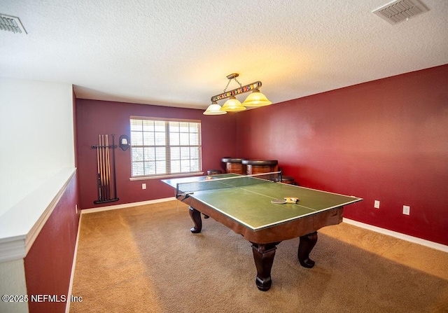 rec room featuring carpet floors, visible vents, a textured ceiling, and baseboards