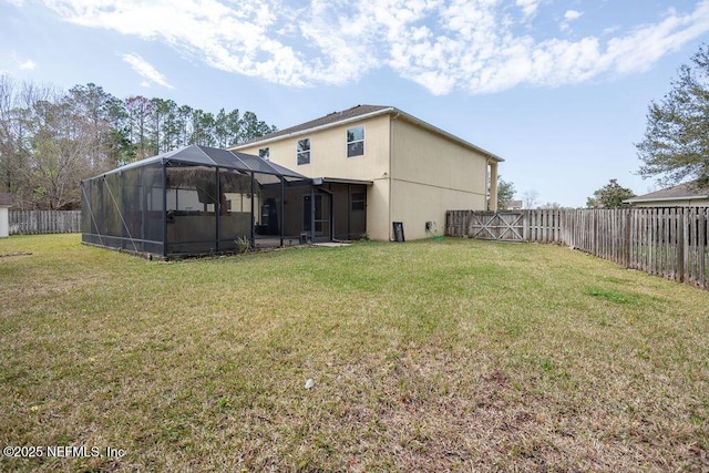 view of yard featuring glass enclosure and a fenced backyard