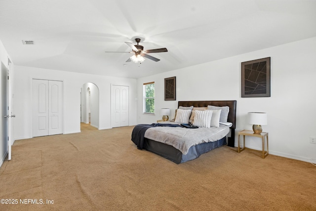 75250 Fern Creek Dr, Yulee, FL 32097 - bedroom with multiple closets, light colored carpet, arched walkways, and a ceiling fan
