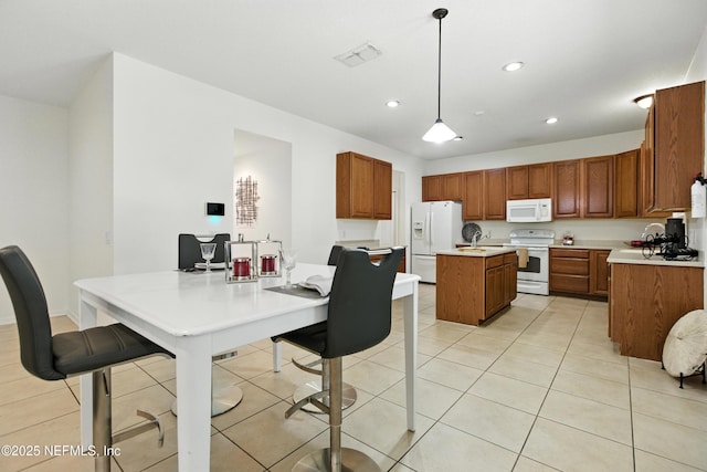 75250 Fern Creek Dr, Yulee, FL 32097 - kitchen with white appliances, a center island, recessed lighting, light countertops, and brown cabinets
