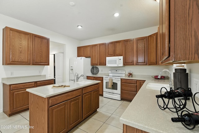 75250 Fern Creek Dr, Yulee, FL 32097 - kitchen featuring white appliances, light tile patterned flooring, light countertops, a kitchen island with sink, and brown cabinets