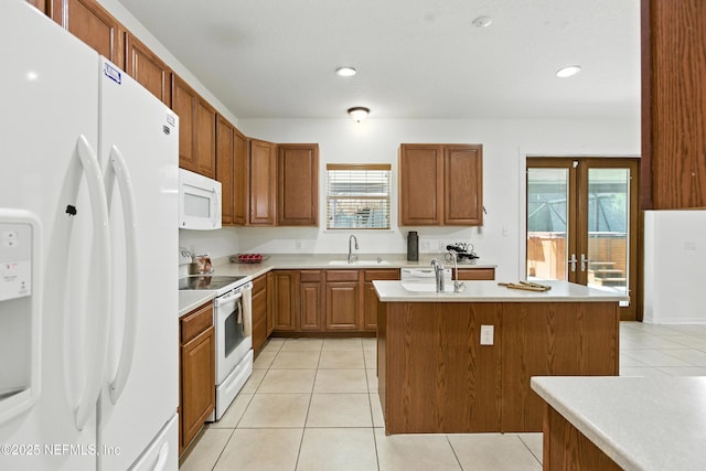 75250 Fern Creek Dr, Yulee, FL 32097 - kitchen with white appliances, light tile patterned floors, an island with sink, light countertops, and brown cabinetry