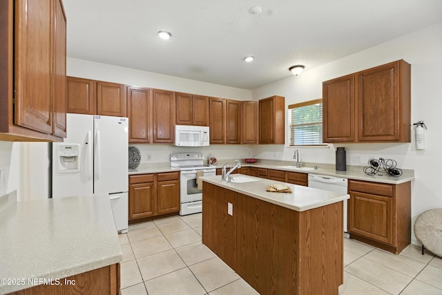 75250 Fern Creek Dr, Yulee, FL 32097 - kitchen featuring white appliances, a center island with sink, light tile patterned floors, light countertops, and brown cabinetry