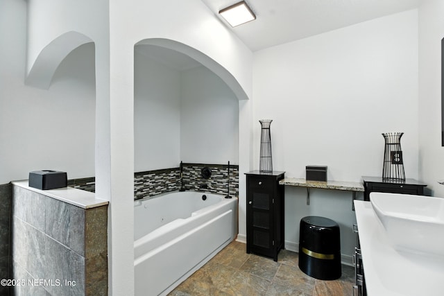 75250 Fern Creek Dr, Yulee, FL 32097 - full bathroom with a tub with jets, stone finish floors, and double vanity