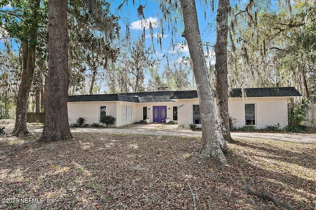 ranch-style house with french doors, roof with shingles, and stucco siding