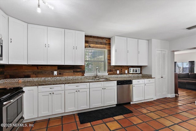 kitchen with appliances with stainless steel finishes, a sink, visible vents, and white cabinets