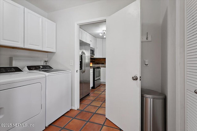 washroom with tile patterned flooring, cabinet space, and washer and dryer