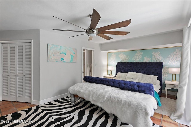 bedroom featuring a closet, tile patterned floors, a ceiling fan, and baseboards