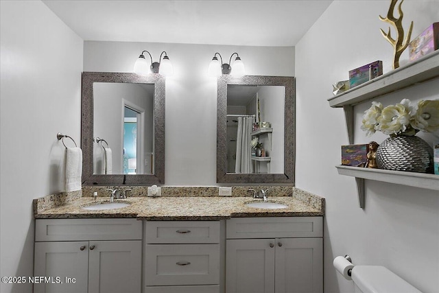 bathroom featuring a shower, a sink, toilet, and double vanity