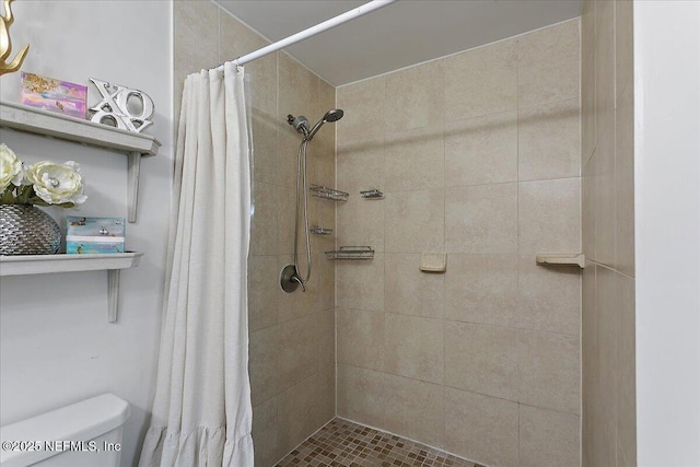 full bath with a tile shower and toilet