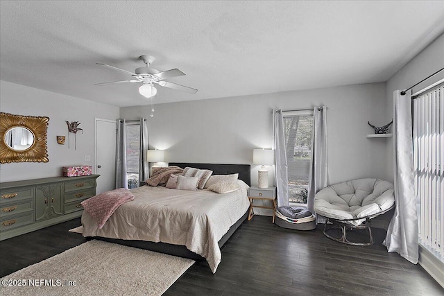 bedroom featuring ceiling fan, dark wood finished floors, and a textured ceiling