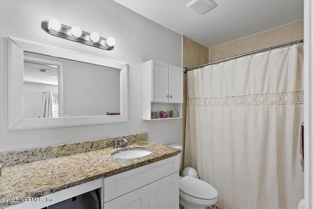 bathroom with toilet, visible vents, and vanity