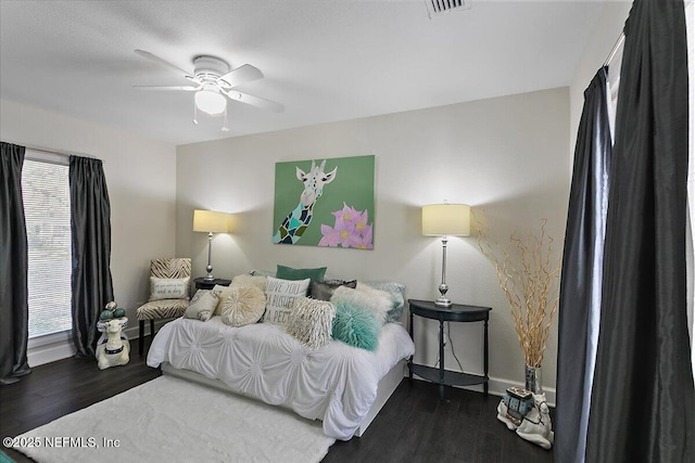 bedroom featuring ceiling fan, visible vents, and wood finished floors