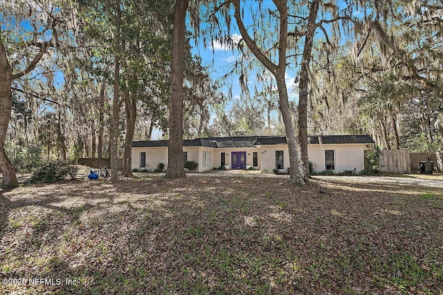 view of front of home with fence and stucco siding