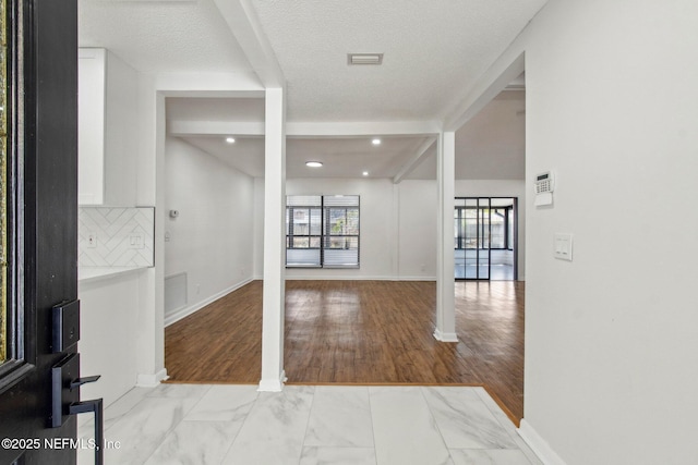 entrance foyer with marble finish floor, visible vents, and baseboards